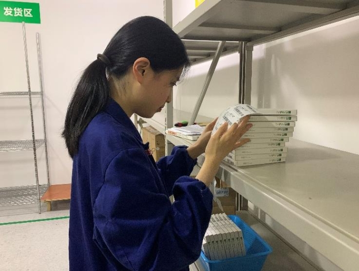 圖為金華市中心醫(yī)院工作人員將追溯二維碼粘貼到醫(yī)療器械包裝盒上。何璇 攝