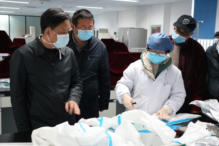 圖為湖北省藥監(jiān)局鄧小川（左一）帶領(lǐng)武漢分局執(zhí)法人員對防護(hù)用品生產(chǎn)企業(yè)進(jìn)行現(xiàn)場檢查。（湖北省藥監(jiān)局武漢分局供圖）