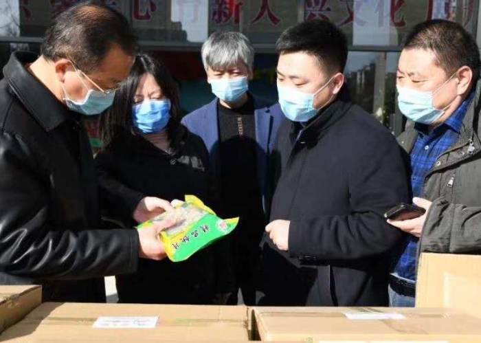 張艷琴（左二）接受企業(yè)捐贈(zèng)抗疫物資。