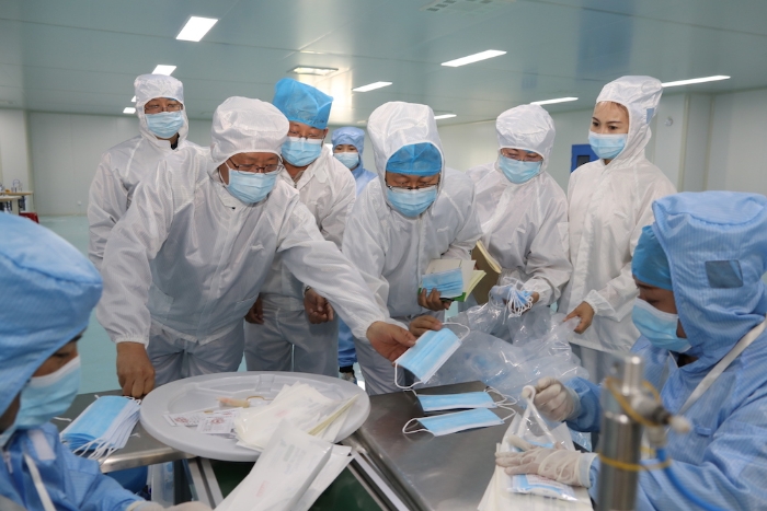 “五_一”小長(zhǎng)假期間，新疆維吾爾自治區(qū)藥監(jiān)局黨組書記、局長(zhǎng)張鈺祥（左一）帶隊(duì)赴哈密市調(diào)研口罩生產(chǎn)企業(yè)。（馬少賓 攝）