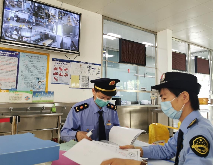 海淀區(qū)市場(chǎng)監(jiān)管局監(jiān)管人員檢查學(xué)校食堂進(jìn)貨記錄。（中國(guó)食品藥品網(wǎng)記者王曉冬 攝）