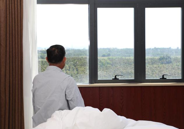 圖為患者盼來救命藥后凝望窗外。