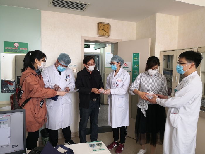 工作人員向醫(yī)護(hù)人員贈(zèng)送化妝品安全科普宣傳手冊(cè)