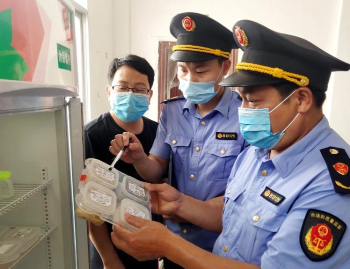 圖為6月8日該局執(zhí)法人員在一鄉(xiāng)鎮(zhèn)學校食堂檢查食品留樣。