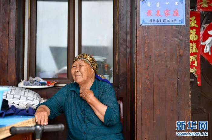 中妮浩坐在位于敖魯古雅鄂溫克族鄉(xiāng)的家門口休息（7月14日攝）。 新華社記者 貝赫 攝