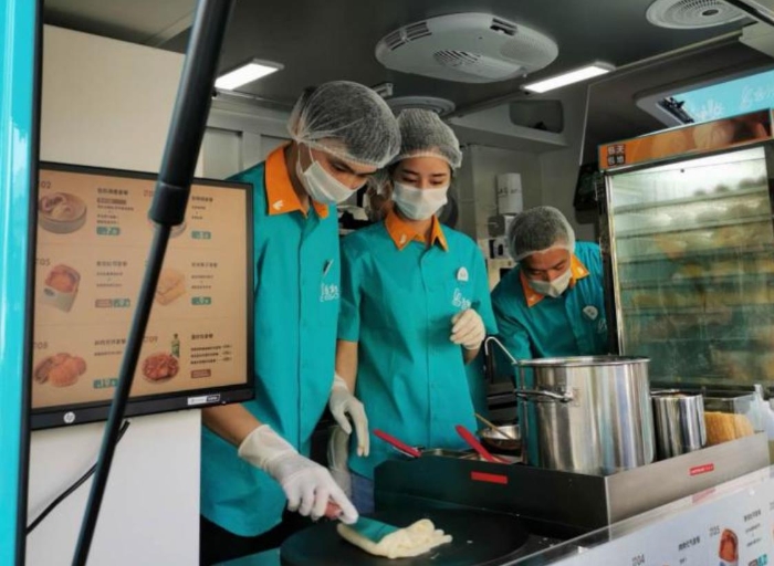 “逸小兔”流動(dòng)早餐車(chē)的店員正在為顧客備餐。新華網(wǎng)發(fā)（熊多多 攝）