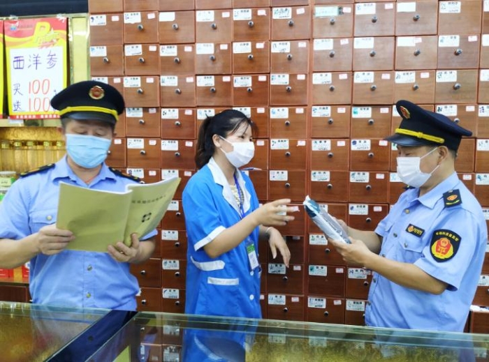 圖為執(zhí)法人員在一家零售藥店檢查中藥飲片進貨臺賬、質(zhì)量安全等情況。