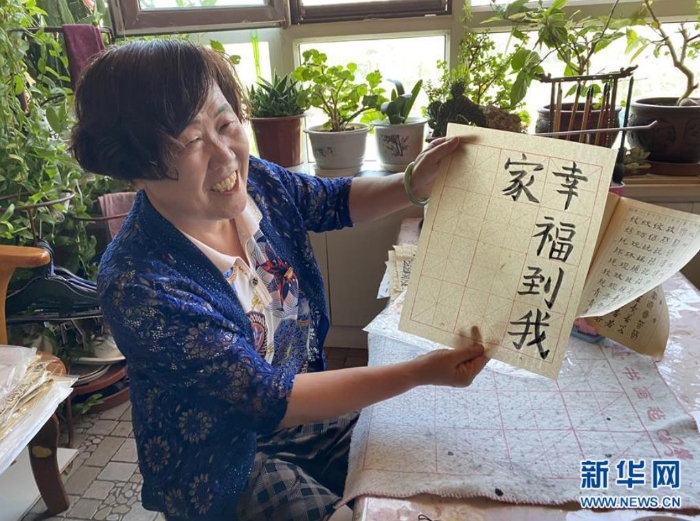 袁秀梅在自家書(shū)房寫(xiě)下“幸福到我家”幾個(gè)字（8月18日攝）。 新華社記者 汪亞 攝