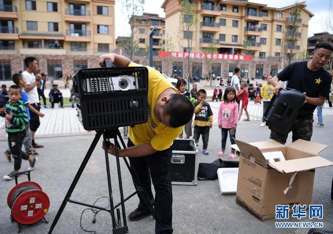 搬下山的人們，住進了有彝族傳統(tǒng)建筑風格的新社區(qū)，每隔一段時間就會有縣里的放映隊為這里的群眾放露天電影（8月11日攝）。 新華社記者 李賀 攝