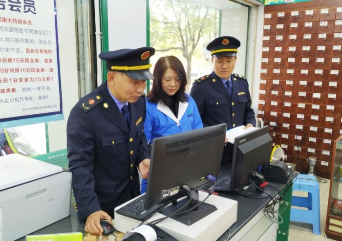 圖為執(zhí)法人員在查看藥店處方藥銷售臺(tái)賬。