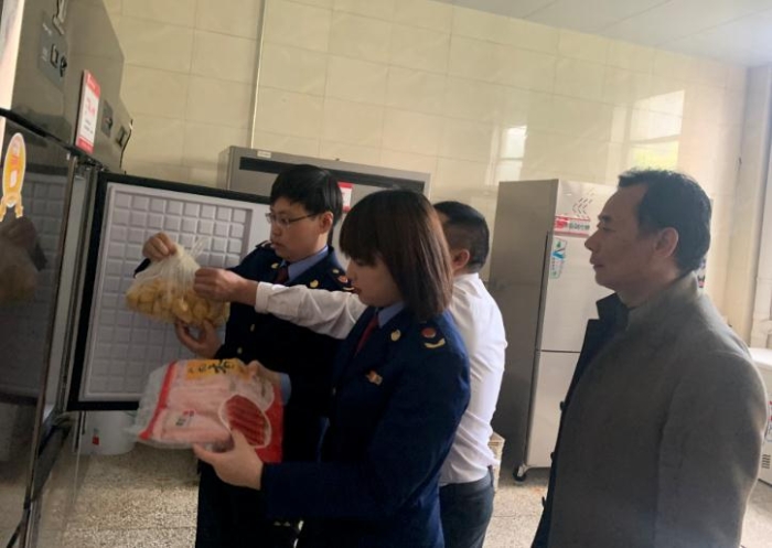 圖為該局執(zhí)法人員檢查學(xué)校食堂食品原料。