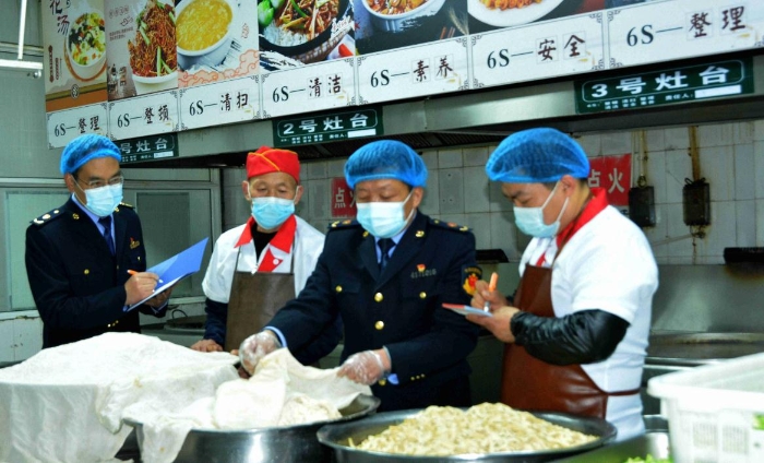 圖為4月7日，執(zhí)法人員在檢查某學(xué)校食堂操作間衛(wèi)生。