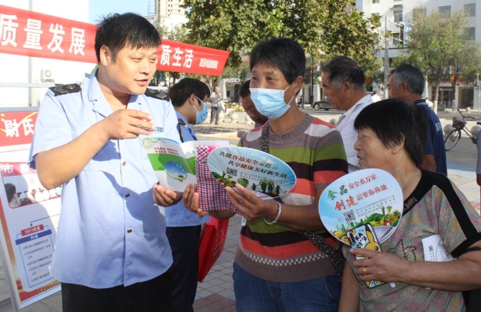 圖為執(zhí)法人員向群眾宣講食品安全知識(shí)。