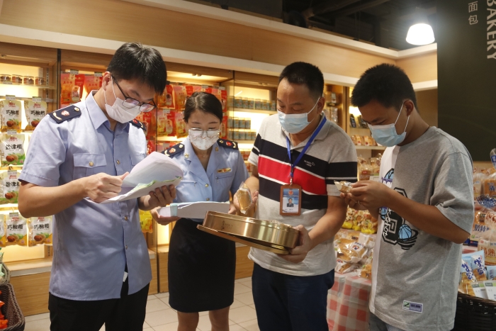 圖為執(zhí)法人員查看月餅質(zhì)量情況。（柯潔 攝）