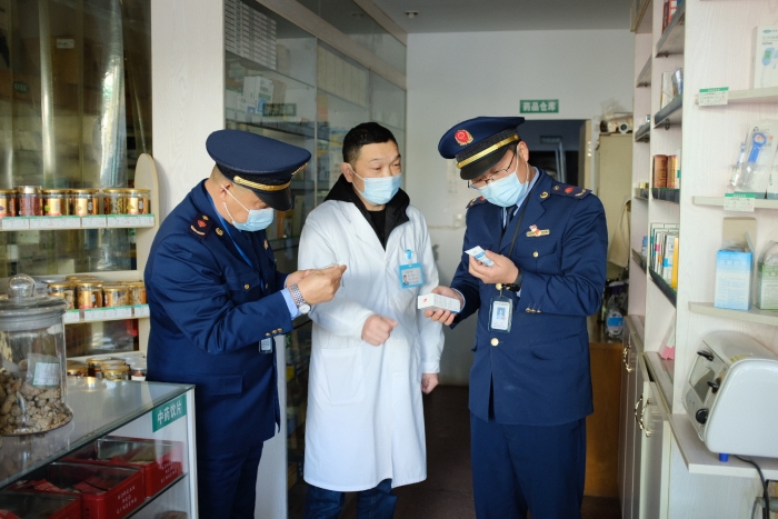 圖為執(zhí)法人員在一家藥店檢查其經(jīng)銷的藥品外包裝上標簽是否規(guī)范，并核對相關購銷登記臺賬的信息是否合規(guī)。