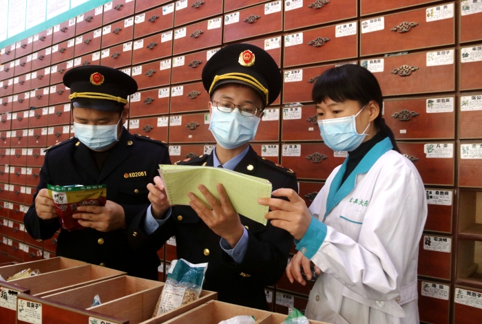 圖為11月24日執(zhí)法人員對一家藥店檢查中藥飲片。