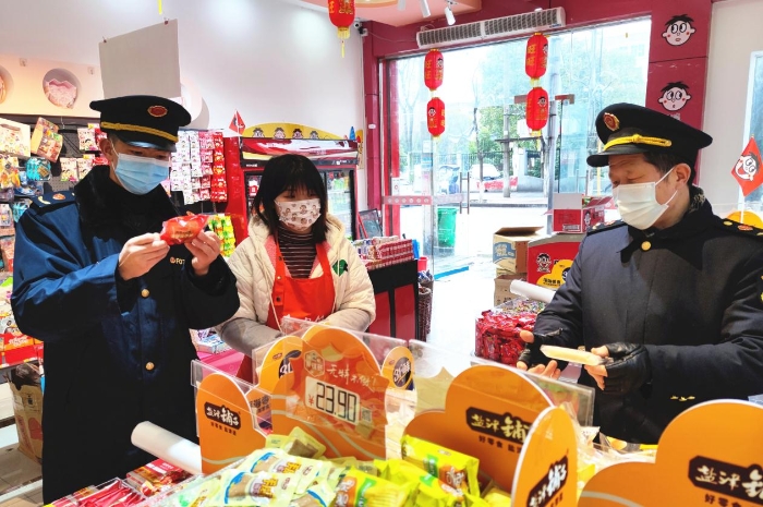 圖為執(zhí)法人員在學(xué)校周邊超市檢查兒童食品質(zhì)量。