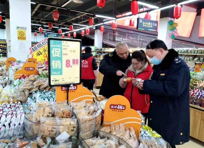 圖為執(zhí)法人員在檢查散裝餅干的生產(chǎn)日期。（王玲玲 攝）