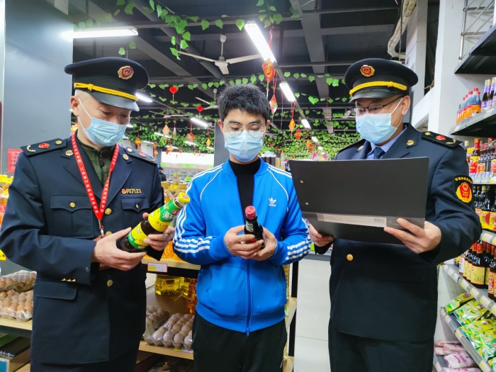 圖為執(zhí)法人員在一家超市檢查調(diào)味品質(zhì)量。