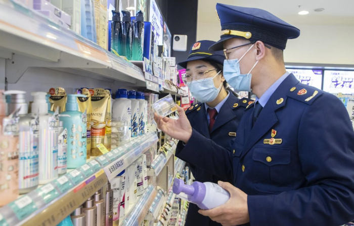 圖為執(zhí)法人員在超市化妝品專柜檢查化妝品標簽標識情形。