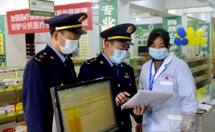 圖為執(zhí)法人員在一家藥店檢查疫情防控藥械銷售記錄。