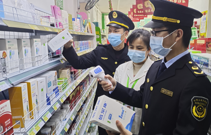 圖為執(zhí)法人員在一家藥店檢查額溫槍。