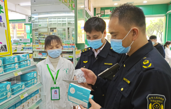 圖為執(zhí)法人員在一藥店查看抗原檢測(cè)試劑材料。