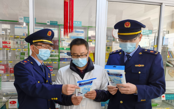 圖為執(zhí)法人員檢查藥店防疫物資。