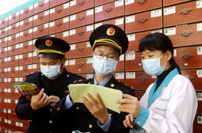 圖為執(zhí)法人員檢查中藥飲片。