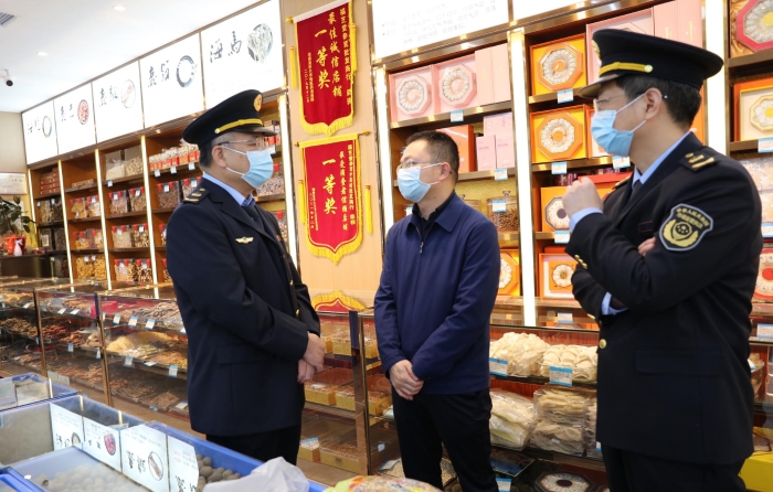 秦繼紅（左一）在中藥材市場聽取長沙市、雨花區(qū)市場監(jiān)管局負責人介紹相關情況。（喻燦華 攝）
