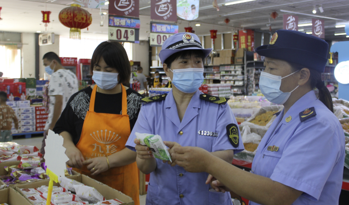 圖為執(zhí)法人員在一家商場食品專柜進行執(zhí)法檢查。
