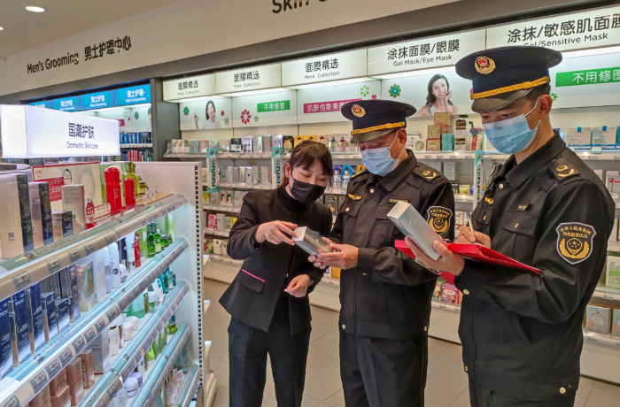 圖為該局執(zhí)法人員在一家化妝品專賣店檢查潤膚霜產(chǎn)品說明。