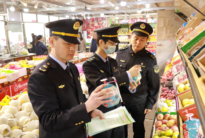 圖為武清區(qū)市場監(jiān)管局執(zhí)法人員在農(nóng)貿(mào)市場檢查食品是否在保質(zhì)期內(nèi)。