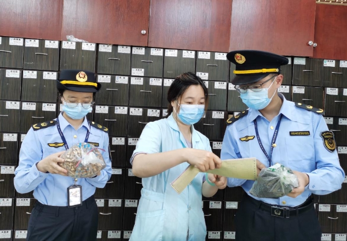 圖為執(zhí)法人員對中藥飲片進行現(xiàn)場檢查。