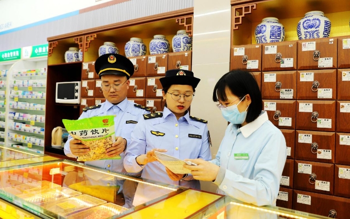 圖為4月25日，執(zhí)法人員在對一家零售藥店的中藥飲片進(jìn)行檢查。