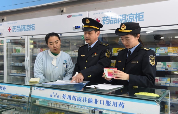 圖為執(zhí)法人員在一家藥品經(jīng)營企業(yè)檢查藥品采購和陰涼藥品儲存記錄情況。