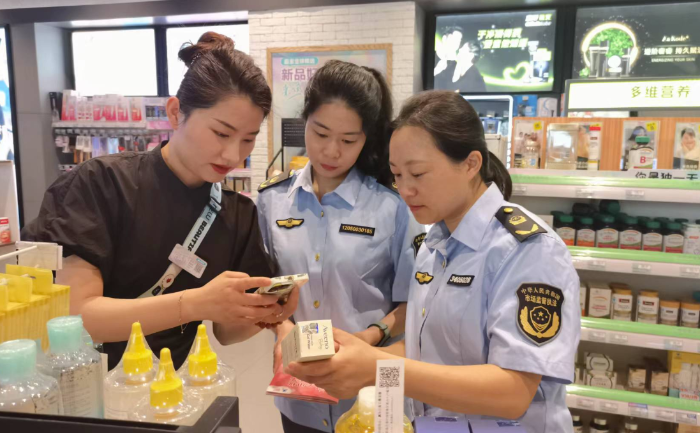 圖為該局執(zhí)法人員在一家化妝品專營店開展檢查并指導(dǎo)工作人員操作化妝品監(jiān)管APP。