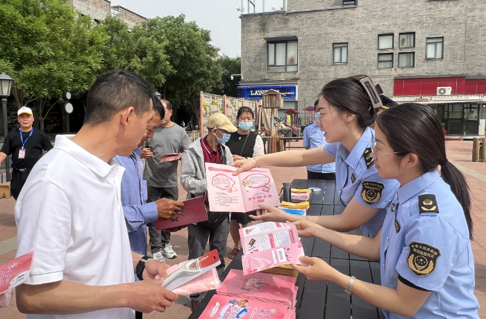 圖為該局監(jiān)管人員向社區(qū)居民發(fā)放化妝品科普手冊。