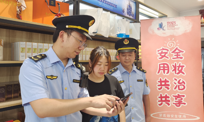 圖為執(zhí)法人員指導(dǎo)經(jīng)營(yíng)戶使用“數(shù)字辨妝”一體化監(jiān)管平臺(tái)的云管理模塊。