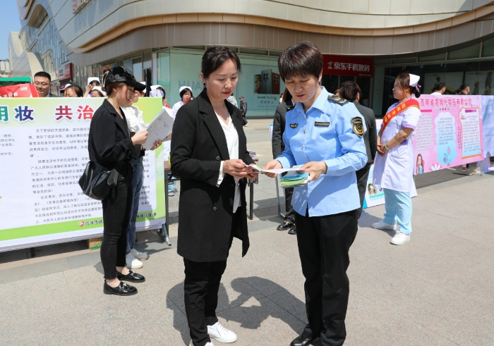 圖為監(jiān)管人員為群眾講解化妝品安全科普知識。（葉陽歡 攝）