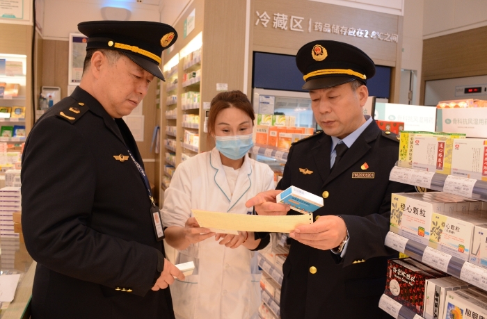 圖為執(zhí)法人員在一家藥品經(jīng)營(yíng)企業(yè)檢查抗病毒藥品的購(gòu)進(jìn)情況。
