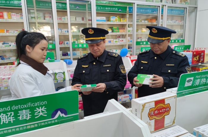 圖為執(zhí)法人員在藥店檢查抗病毒類藥品質(zhì)量情況。