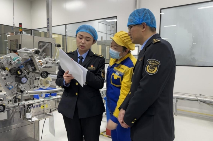 圖為監(jiān)管人員在外包裝間查看產品批生產記錄。（齊桂榕 攝）