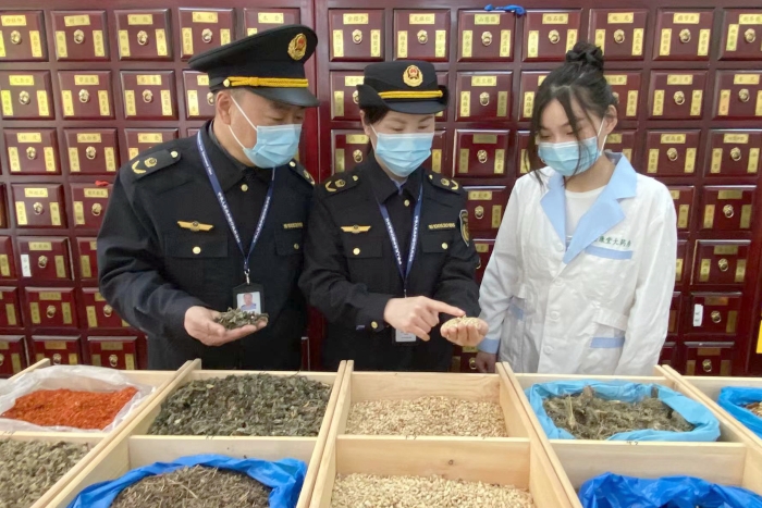 圖為執(zhí)法人員檢查中藥飲片。