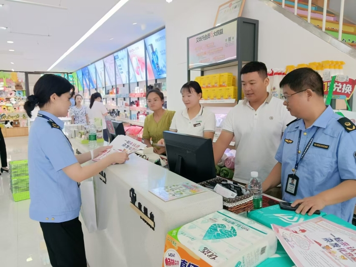 圖為執(zhí)法人員在一家商場(chǎng)發(fā)放宣傳材料。