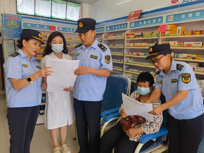 圖為該局執(zhí)法人員在一家藥店開展普法宣傳活動。