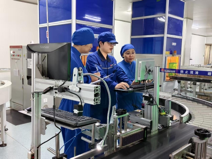 圖為第三分局執(zhí)法人員在一家藥品生產(chǎn)企業(yè)車間現(xiàn)場對藥品包裝賦碼情況進行檢查。（盧昶君 攝）