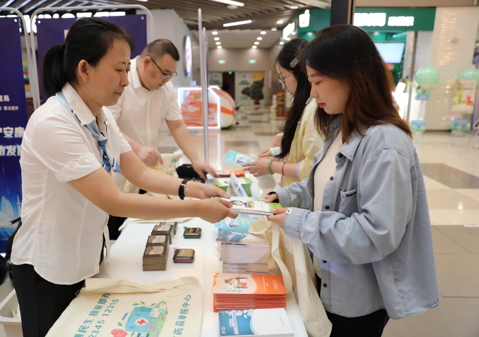 圖為工作人員向市民發(fā)放《藥品管理法實施條例》解讀以及用藥安全科普知識宣傳手冊。（葉陽歡攝）